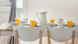 Una colazione allestita con un tavolo, sedie, una lampada e una finestra con tende.