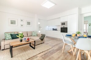 Eine moderne Wohnung mit Wohnzimmer, Küchenzeile und Essbereich.