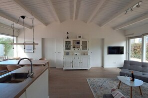 Eine moderne Küche mit Spüle, Essbereich und einem weißen Schrank mit Glastüren.