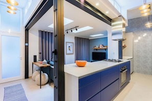 A modern kitchen with a central island, built-in appliances, and a view to the living area. - Stylish 2BR Apartment Ideal for Monthly Stays (Lisbon)