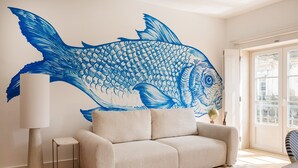 A room with a large fish mural, a sofa, a lamp, and a view through a door. - Baixa Rooftop Duplex Lisbon (Lisbon)