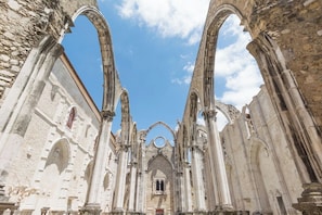 An interior view of a historic building with Gothic arches and stone columns. - Baixa Rooftop Duplex Lisbon (Lisbon)
