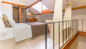 A bedroom with a bed, bedside table, and a hanging light fixture. - Gaia Stone House (Vila Nova de Gaia)