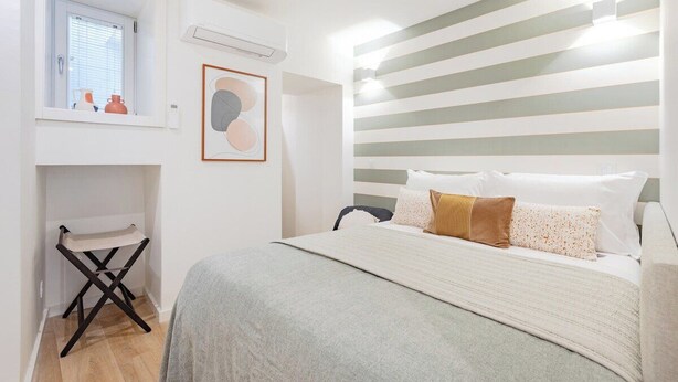 A bedroom with a bed, a window, a radiator, and a wall-mounted shelf. - Studio Pop 111 Collection (Porto)