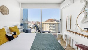 A modern hotel room with a large bed, a balcony with a view, a white console table, and a large window. - Blue Breeze Espinho Pool View, Gym Balcony (Espinho)