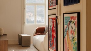A room with a bed, a window, and wall-mounted artwork. - Oasiys - Your Getaway in Porto (Porto)