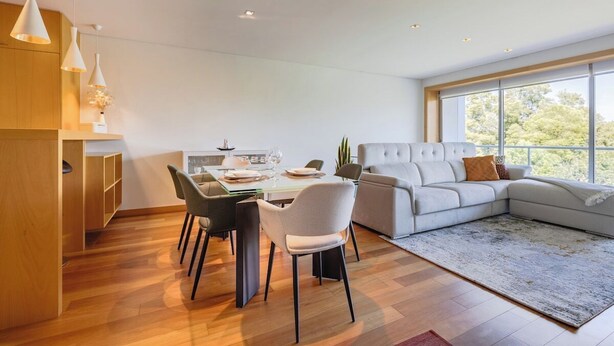 A modern living room with a sectional sofa, dining table with chairs, and pendant lighting. - Gaia Prime Serenity (Vila Nova de Gaia)