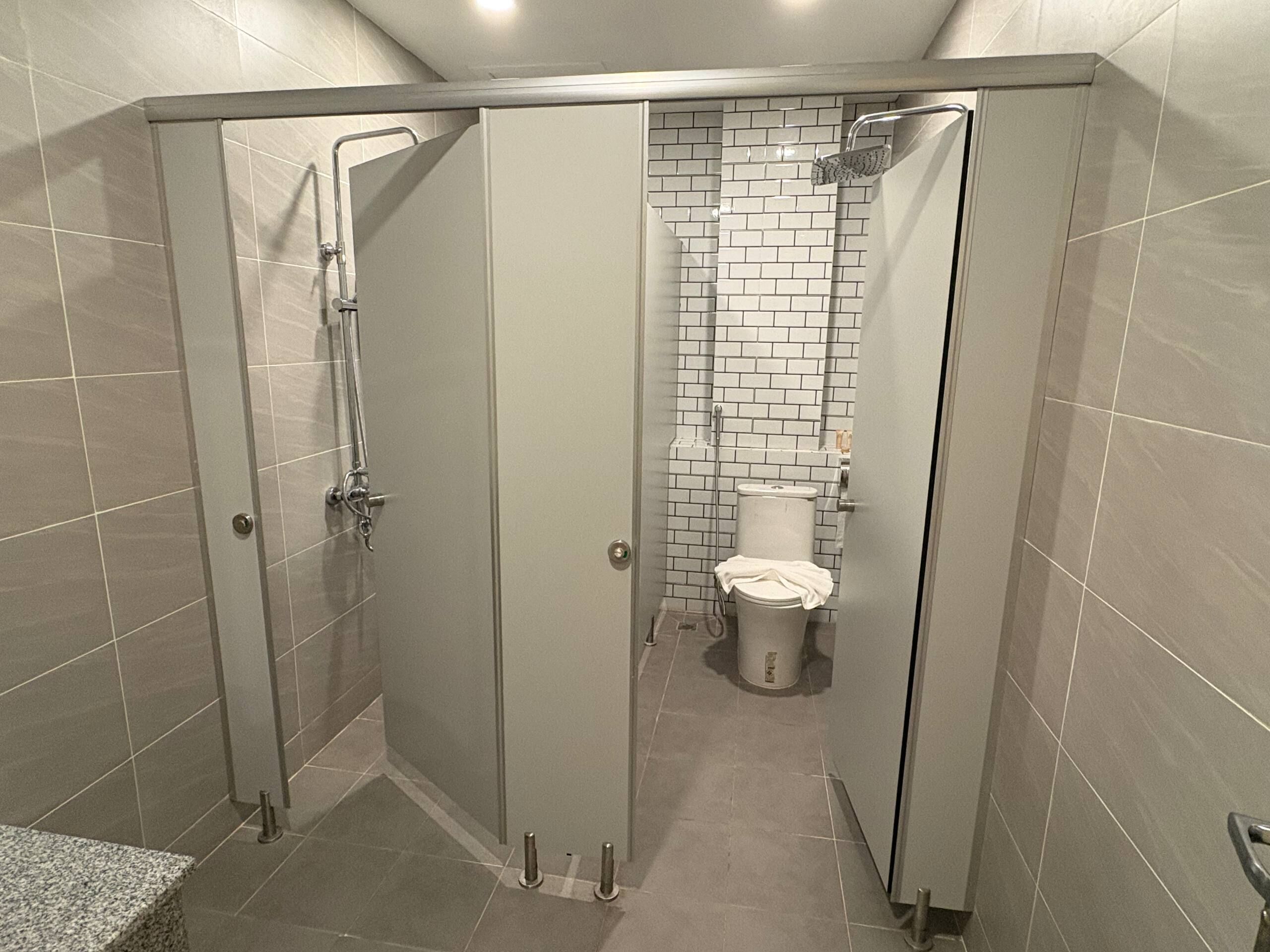 Un baño moderno con ducha, inodoro y puertas de vidrio.
