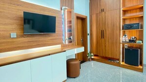 A modern kitchen with a built-in TV, wooden cabinets, and a marble floor.