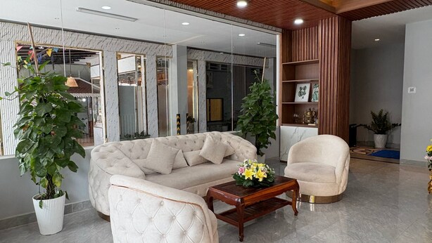 A modern living room with a sectional sofa, a wooden coffee table, and two potted plants.