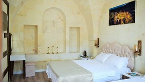 A hotel room with a bed, bedside tables, a nightstand, a mirror, and a painting on the wall. - Hasbahan Konak (Sanliurfa)