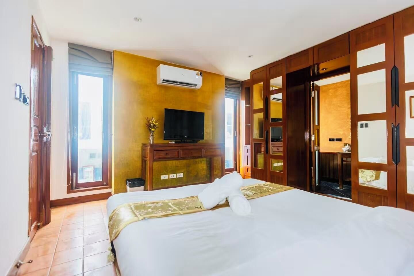 Une chambre d’hôtel équipée d’un lit, d’une télévision, d’un climatiseur et d’une armoire.