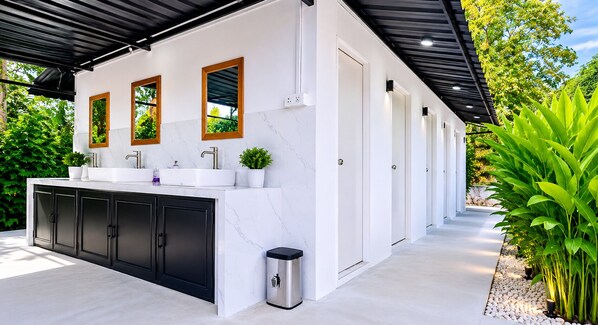 Una cocina moderna con encimera de mármol, armarios negros y un cubo de basura.