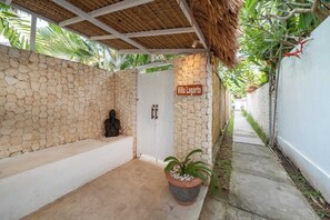 Ein Badezimmer mit Steinsäulen, einer Badewanne, einem Topfpflanzen und einem Schild mit der Aufschrift 'Villa Lagarto'.