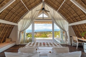 Ein Schlafzimmer mit einem großen Bett, einem Schreibtisch und Blick auf die Landschaft.