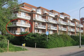 A multi-story residential building with balconies, a pedestrian sign, and a clear sky. - Holiday Residence Albatros (Cuxhaven-Döse)