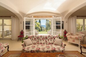 Ein Wohnzimmer mit einem floralen Sofa, einem roten Sessel und einem Vintage-Sessel.
