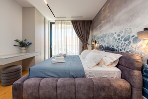 Ein modernes Schlafzimmer mit Bett, Nachttisch und Wandbild.
