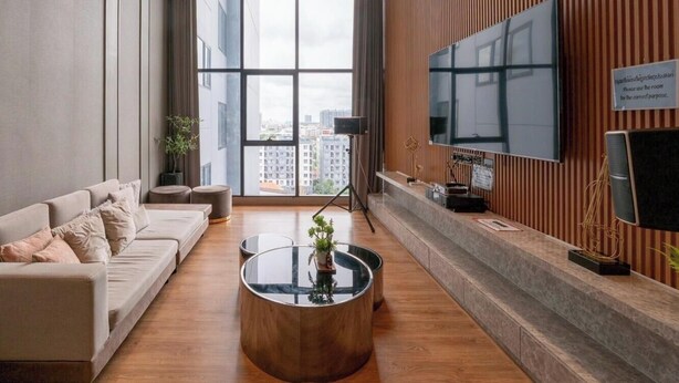 Ein modernes Wohnzimmer mit einer Couch, einem Couchtisch und einem an der Wand befestigten Flachbildfernseher.
