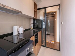 A modern kitchen with a built-in stove, a coffee maker, and a sink. - Уютная современная квартира возле метро и ТЦ Аренда от 10 дней (Krung Thep Maha Nakhon)