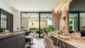 A modern dining area with a large table, chairs, and a chandelier. - Villa Marro ZadarVillas (Privlaka)