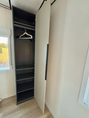 Vaatehuone, jossa on henkaritanko ja useita hyllyjä.