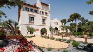 Un edificio con una entrada curva, rodeado de jardines y árboles cuidados.