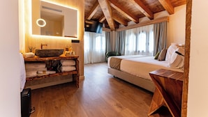 Un dormitorio con techo de madera, un espejo grande con iluminación, una cama y una mesita de noche de madera.
