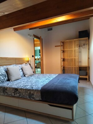 A bedroom with a bed, a wardrobe, and a bathroom visible through an open door.
