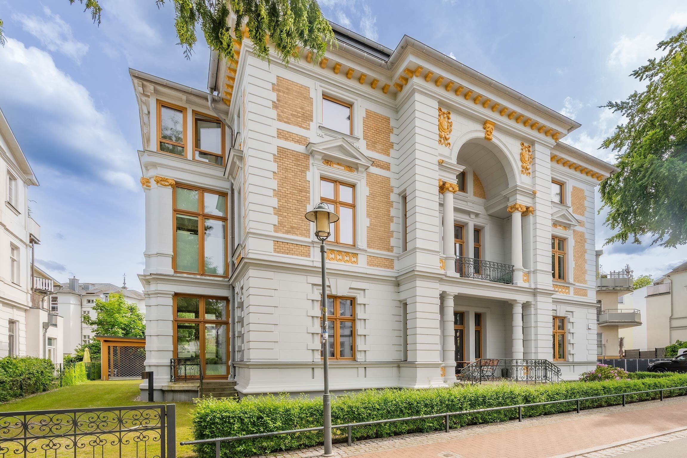 A multi-story building with a symmetrical facade, large windows, and a central entrance with a balcony.