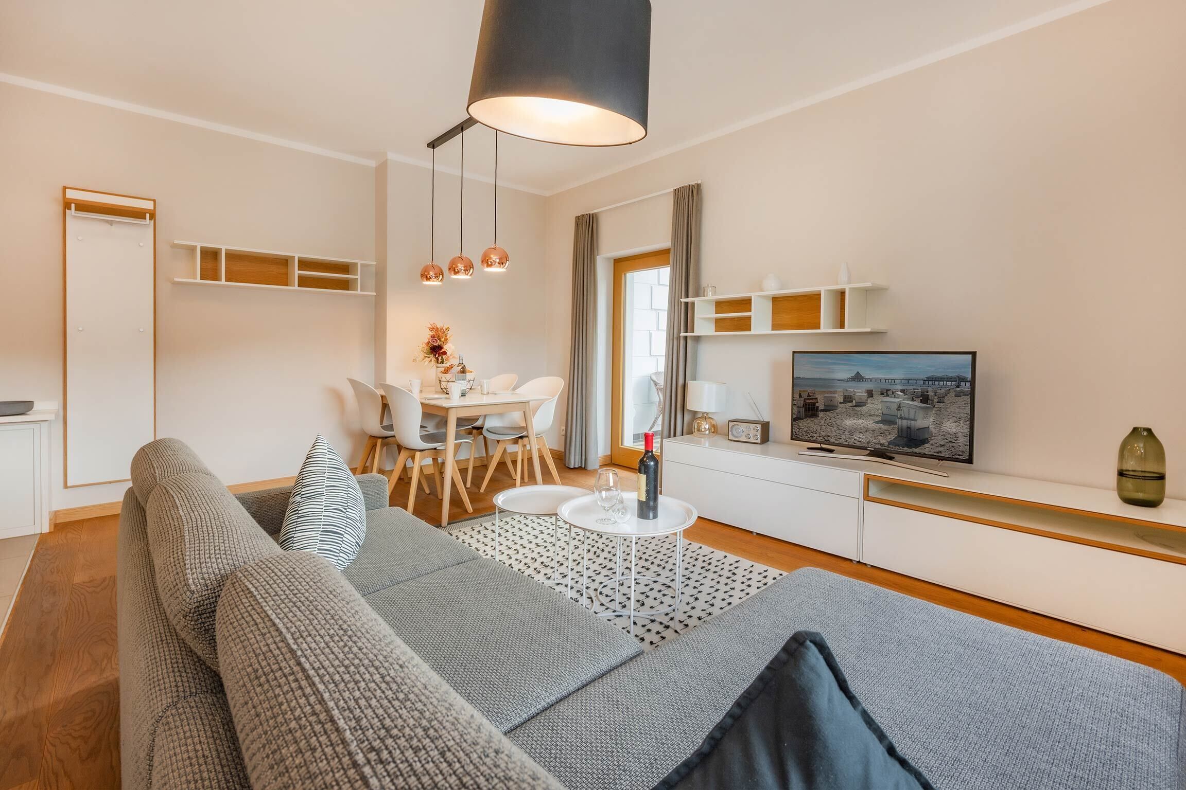 Un salon moderne avec un canapé, une table à manger et un téléviseur.