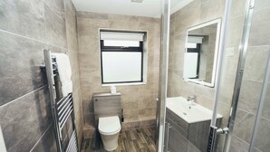 Un bagno moderno con servizi igienici, lavandino e doccia.