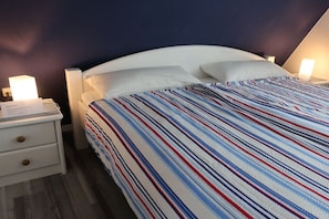 Ein Hotelzimmer mit einem Bett, zwei Nachttischen und einem Beistelltisch.