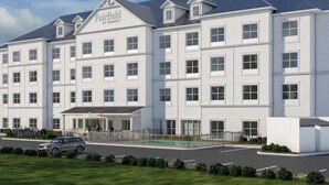 A multi-story hotel with a symmetrical facade, large windows, and a covered entrance. - Fairfield by Marriott Inn & Suites Nags Head (Nags Head)