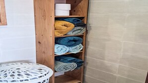 Ein Holzregal mit gefalteten Handtüchern in verschiedenen Farben.