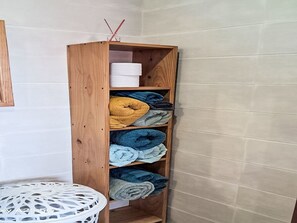 Ein Holzregal mit gefalteten Handtüchern in verschiedenen Farben.