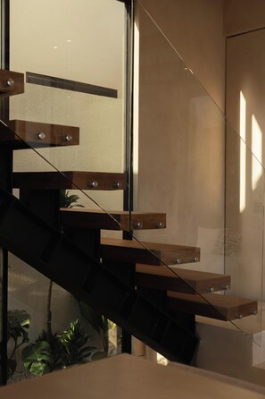 A modern staircase with glass railings and wooden steps. - Maison Kala (Cemagi)