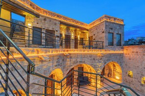 A stone building with multiple arches and a staircase.