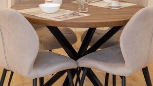 Eine moderne Küche mit weißen Schränken, einer Holz Arbeitsplatte und einem Esstisch mit vier Stühlen.