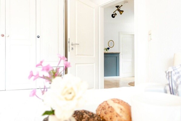A room with a bed, a white door, a blue cabinet, and a hanging light fixture. - Edelhusen holiday home (Aurich)