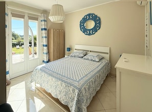 A bedroom with a bed, a bedside table, a mirror, and a view of the outdoors. - Charming villa with a private pool in the heart of the Var (La Motte)