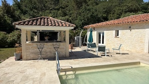 A poolside area with a pergola, outdoor seating, and a stone building. - Charming villa with a private pool in the heart of the Var (La Motte)