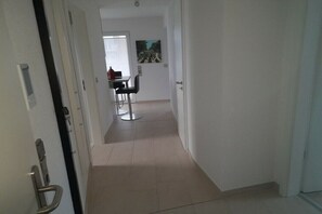 Een gang die uitkomt in een eetruimte met een tafel en stoelen.