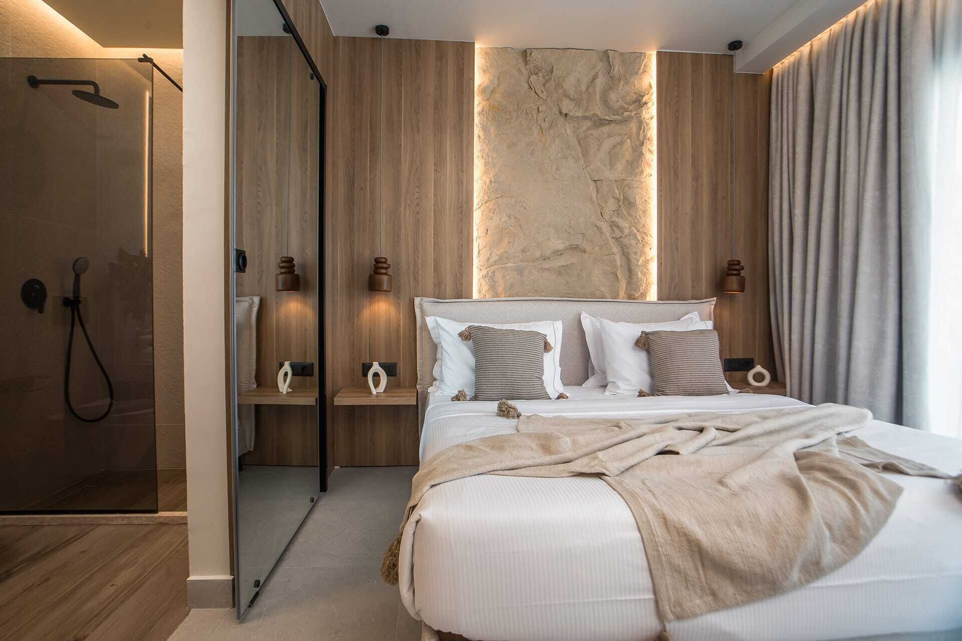 Een moderne slaapkamer met een groot bed, houten paneelwanden, een accentmuur van steen en een inloopdouche.