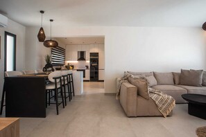 Eine moderne Küche mit Essbereich, einer Couch und einem Couchtisch.