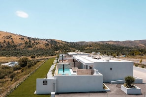 A modern building with a rooftop pool, surrounded by a landscaped garden and a hilly landscape. - Celeste Luxury Villas | Villa Gea, Villa (Rhodes)