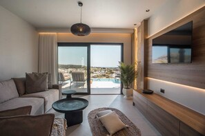 Un salon moderne avec un canapé, une table basse et une vue sur une piscine et le paysage urbain.