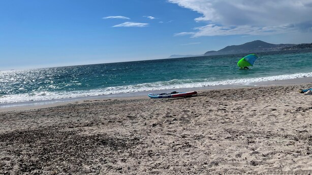 A beach with a clear sky, a body of water, and a distant mountain. - Lou Cri-Cri Apartment in Hyères-les-Palmiers on Montée de Costebelle (Hyères)