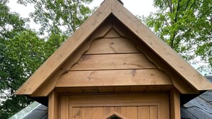A wooden cabin with a hexagonal window and a door. - Finnish kota with a private wood-fired barrel sauna (Slootdorp)