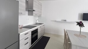 Une cuisine moderne équipée d’un réfrigérateur, d’une cuisinière, d’un évier et de meubles de rangement en bois.